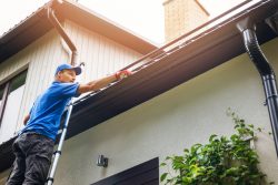 man cleaning gutter