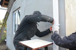 two men fixing a gutter