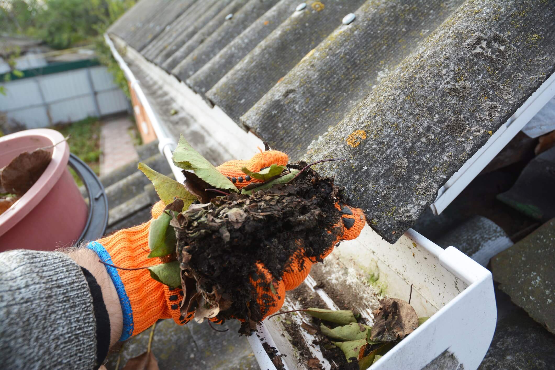 A gutter cleaner cleaning a dirty gutter