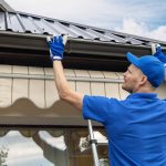 Man installing house roof gutter system